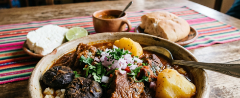 Hearty Andean stew with beef, potatoes, corn, mushrooms, and fresh herbs in a ceramic bowl