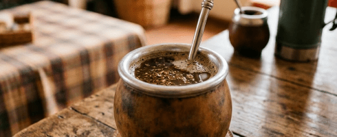 Cup of coffee with spoon on saucer on rustic wooden table