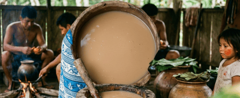 Indigenous woman mixing food in a wooden container with baskets of produce around